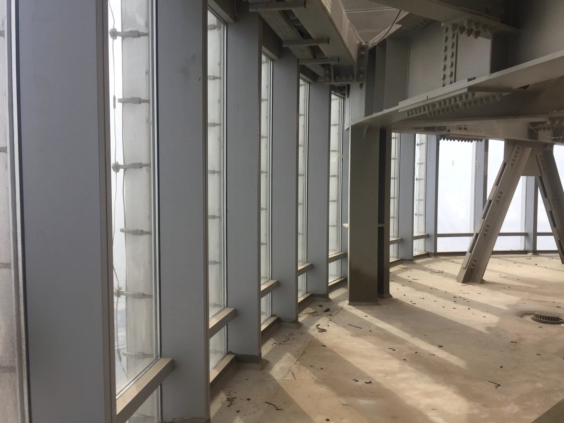 Interior facade glazing and exposed steel framing in an unfinished construction area.